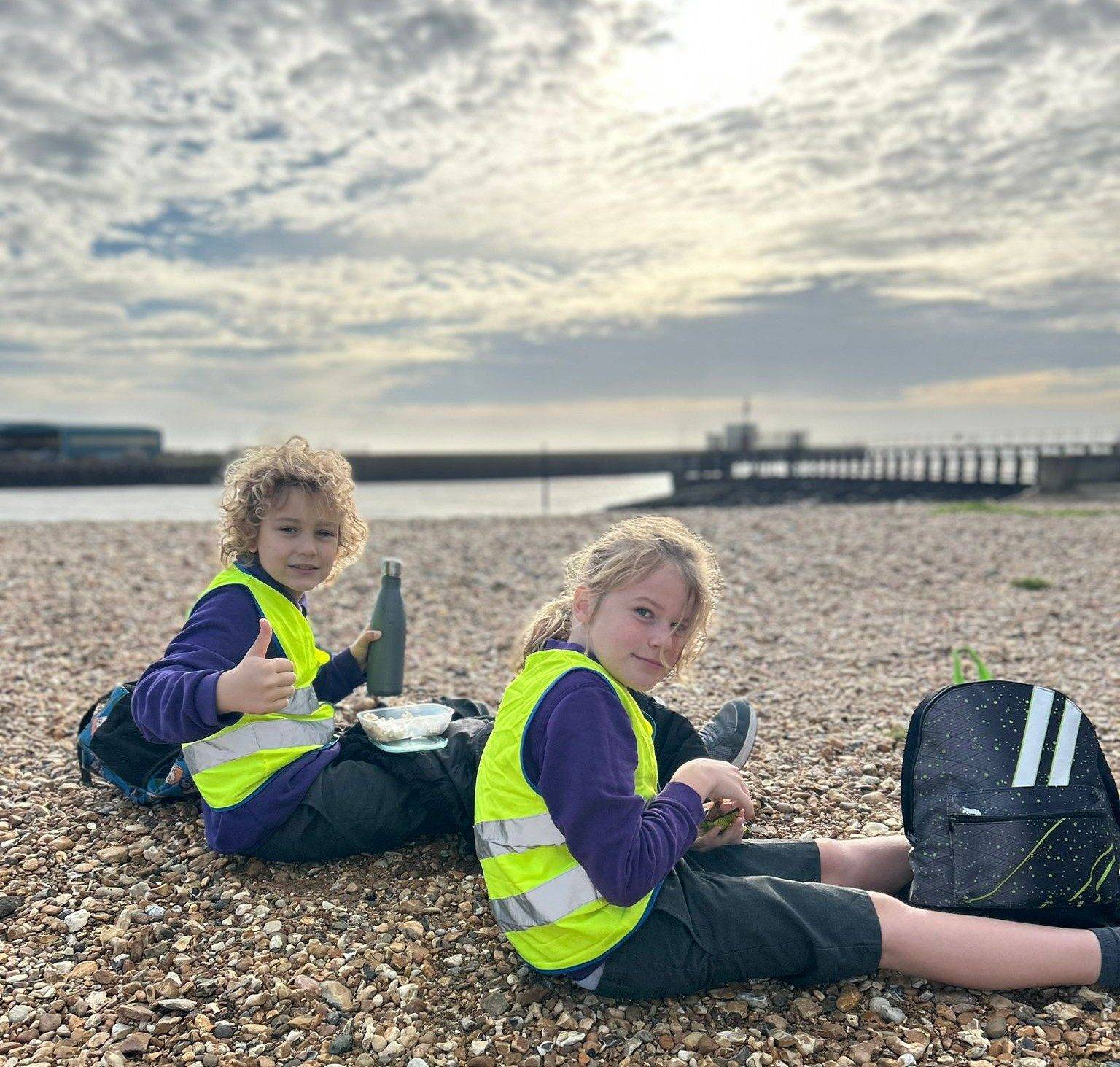 Shoreham Beach Primary pupils sitting on the shingle during a beach school session